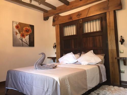 a bird sitting on a bed in a room at Posada el Molino de Cadalso in Cereceda