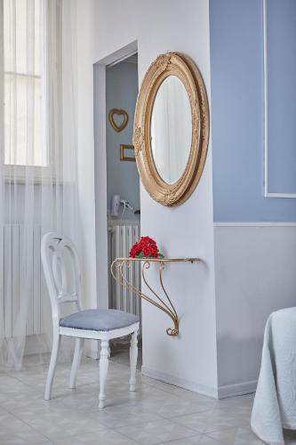 a white room with a chair and a mirror at Il Piccolo Principe Affittacamere in Foligno