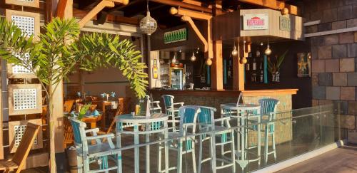 a restaurant with blue chairs and a bar at Azure Beach Boutique Hotel in Grand Baie