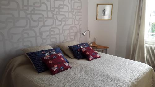 une chambre avec un lit avec deux oreillers dessus dans l'établissement Le gîte de l'atelier, à Bergerac