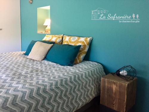 - une chambre avec un lit aux murs bleus et un miroir dans l'établissement La Safranière, à Lagraulet-Saint-Nicolas