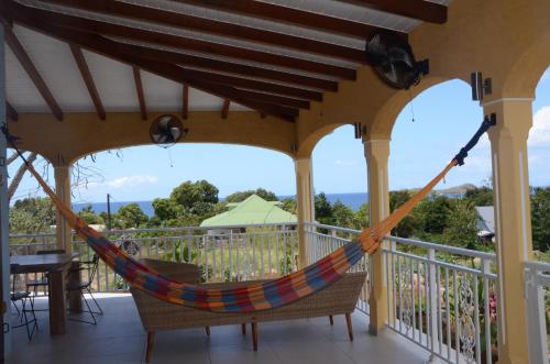 a hammock on the balcony of a house at villa stenella in Bouillante