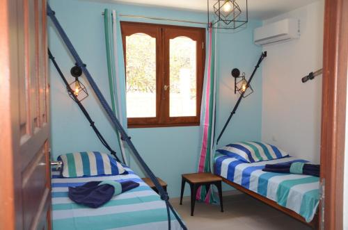 two beds in a room with blue walls at villa stenella in Bouillante