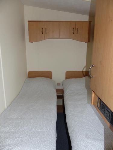 a small room with two beds and wooden cabinets at Domki nad Wartą in Wierzchlas
