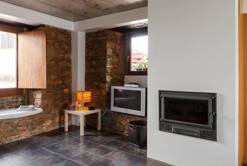 una sala de estar con un televisor y una mesa en Casa De Janeiro, en Janeiro de Cima