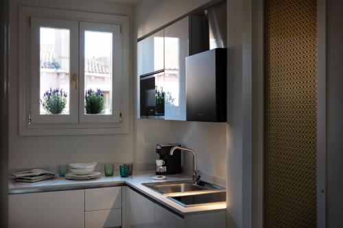 a kitchen with a sink and two windows at Residenza Ducato in Venice