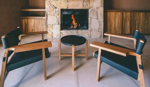 two chairs and a table in front of a fireplace at Rosell Boher Winery Lodge & Spa in Agrelo