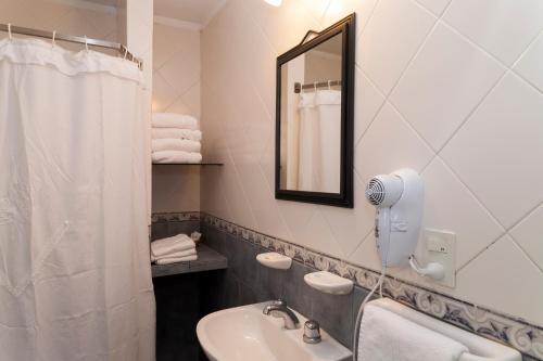 Un baño blanco con lavabo y espejo. en Paihue Cabañas, en Valeria del Mar