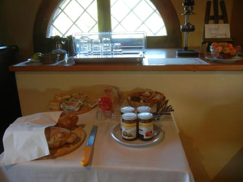 a table with food and two jars of jam at La Colombarola Agriturismo in Farneto