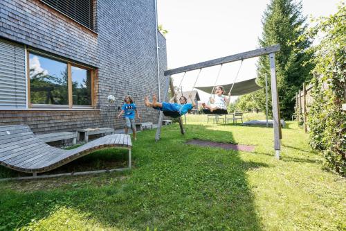 two children playing in a yard with a playground at Gartenwohnung in prämierter Wohnanlage in Klaus