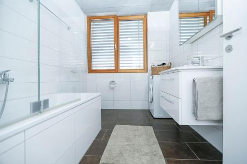 Baño blanco con bañera y lavamanos en Gartenwohnung in prämierter Wohnanlage, en Klaus