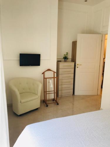 a bedroom with a chair and a television on a wall at Milano Central in Milan