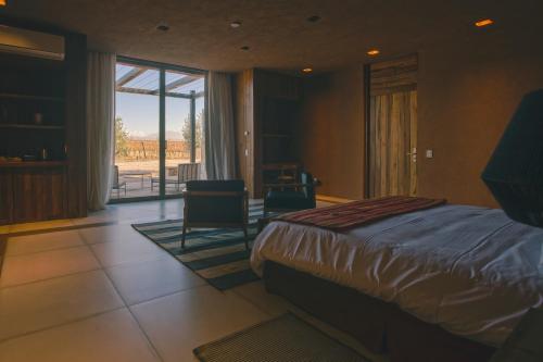 a bedroom with a bed and a view of a patio at Rosell Boher Winery Lodge & Spa in Agrelo
