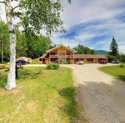 a large building with a tree in front of it at Snowdon Chalet Motel in Londonderry