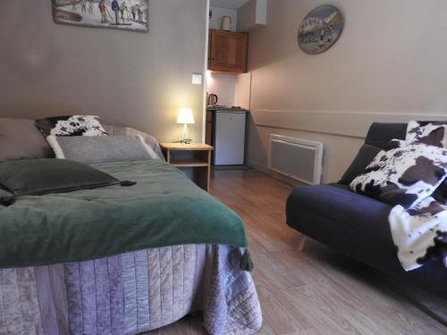 a bedroom with a bed and a couch and a table at Le Lioran Studio les Myrtilles à 200m des pistes in Le Lioran