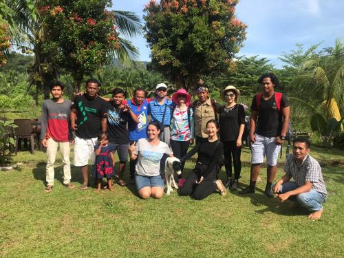a group of people posing for a picture in the grass at Sumatra Cheeky Monkeys in Bukit Lawang