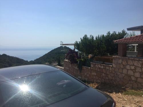 a car parked in front of a house with the view at Xuxi Apartments in Lukovë