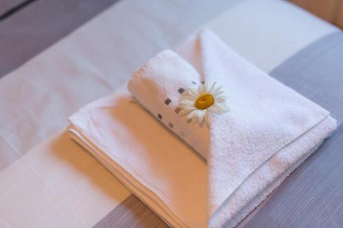 a white towel with a flower on top of it at House Malkoc in Saborsko