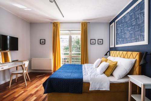 um quarto com uma cama, uma secretária e uma janela em Villa Orla em Gdynia