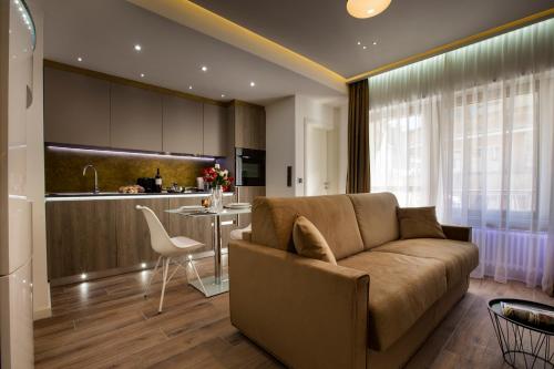 ein Wohnzimmer mit einem Sofa und einer Küche in der Unterkunft The Queen Luxury Apartments - Villa Carlotta in Luxemburg (Stadt)