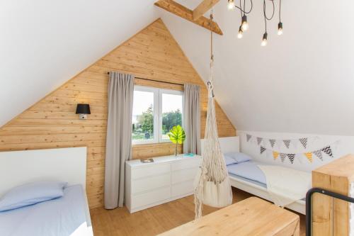 a bedroom with a hammock in a attic at Kompleks Wypoczynkowy Bryza III in Lubiatowo