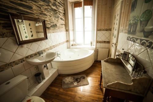 a bathroom with a tub and a sink and a bath tub at La Pause Angevine in Angers