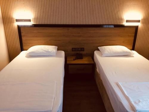 two twin beds in a room with a table at Süvari Hotel in Aksaray