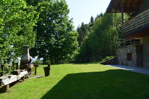 un cortile erboso con un edificio in pietra e una panchina di Walking's House Mountain Lake Iseo Hospitality a Lovere
