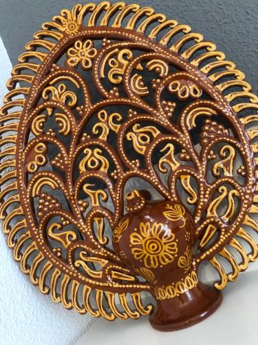 a brown and gold plate with a flower design on it at Alojamiento LA DUQUESITA in Alba de Tormes