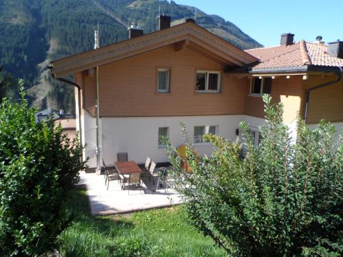 a house with a table and chairs in the yard at Appartementhaus Casamarai in Saalbach Hinterglemm