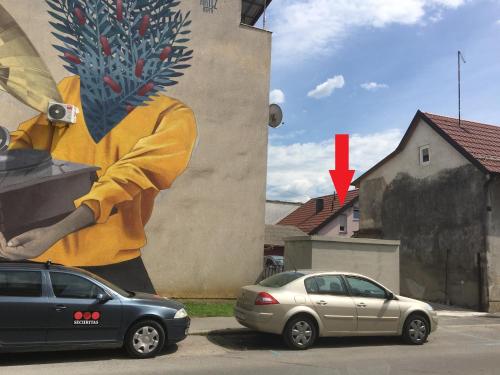a painting of a man on a wall next to cars at Apartment Dada in Bjelovar