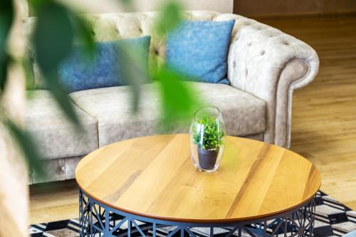 a glass on a table in a living room with a couch at City Avenue Hotel by HMG-Free Parking-Free Wi-Fi in Sofia