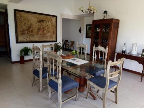 a dining room with a glass table and chairs at Casa Campestre La Quinfalia in Luna Park