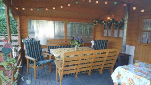 een patio met een houten tafel en stoelen en een tafel en stoelen bij Gästehaus Meierbaude in Kurort Altenberg