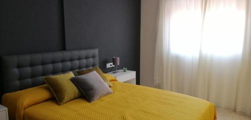 sypialnia z żółtym łóżkiem i oknem w obiekcie Airem 88 w mieście Roquetas de Mar