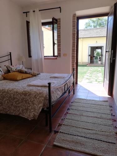 a bedroom with a bed and a door to a yard at Agriturismo Le Folaghe in Terracina