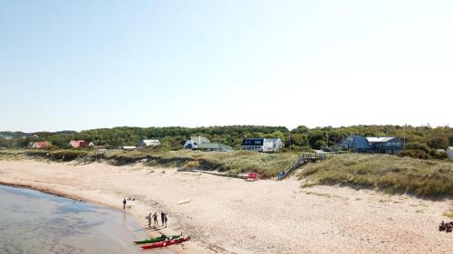 a group of people standing on a beach at Vejby Strand Hotel in Vejbystrand