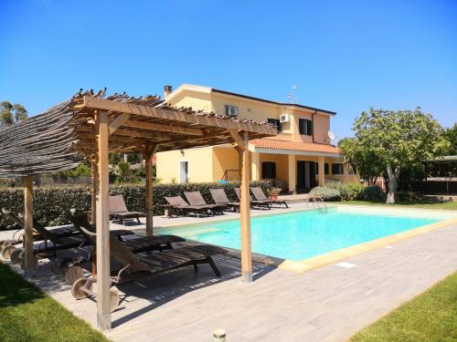 una piscina con pérgola y una casa en Villa Las Rosas en Alguer