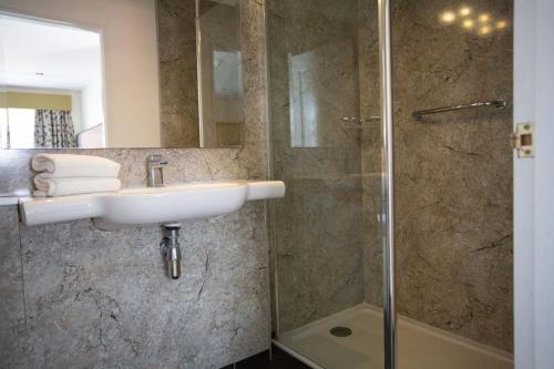 a bathroom with a sink and a shower at Links Country Park Hotel in Cromer