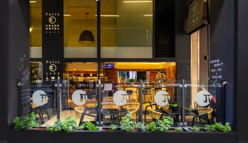 a window of a restaurant with chairs and tables at Polis Grand Hotel in Athens