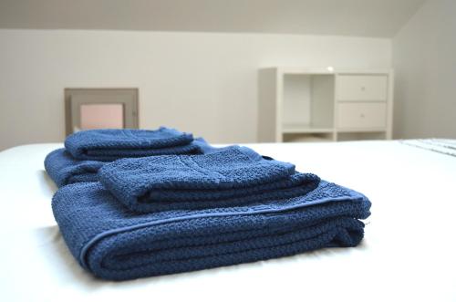 three blue towels sitting on top of a bed at Charmante maisonnette au coeur de ville avec balcon - 70 m2 in Sète