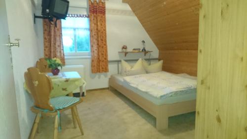 een slaapkamer met een bed, een tafel en een stoel bij Gästehaus Meierbaude in Kurort Altenberg