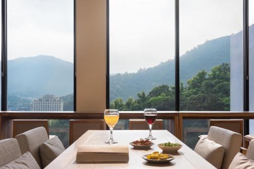 two glasses of wine on a table in front of windows at Lakeshore Hotel Suao in Suao