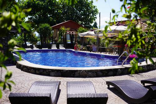 una piscina con 2 sillas y una mesa en Ponto Hotel, en Kobuleti