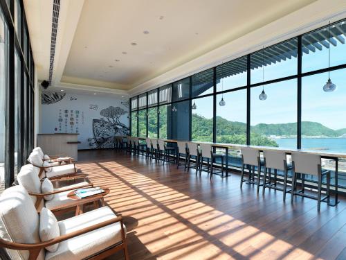a dining room with tables and chairs and large windows at Lakeshore Hotel Suao in Suao