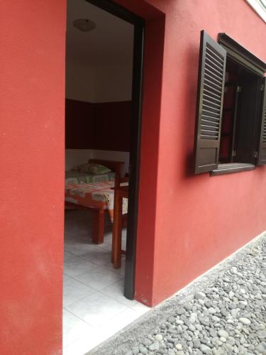 a red building with a window and a table at Aldeia Jerome in Paul