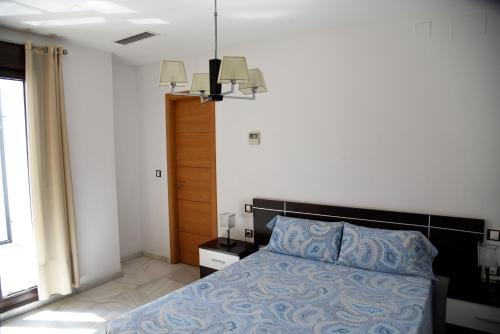 sypialnia z łóżkiem z niebieską kołdrą w obiekcie Modern Atico, Close Macarena/Sevilla center w Sewilli