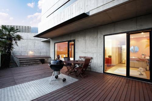 a patio with a grill on a wooden deck at Tropical Dream Spa Resort in Geoje 