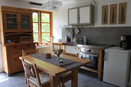 een keuken met een houten tafel, een fornuis en een koelkast bij Kleine Auszeit in Kluis