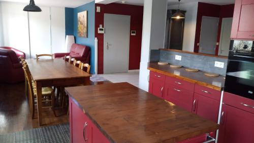 a kitchen with a table and chairs and a refrigerator at Hôtel Patton in Avranches
